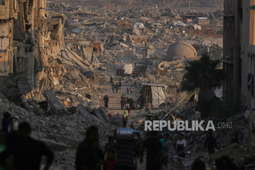 Warga Palestina melewati kehancuran akibat serangan udara dan darat Israel di Kota Gaza, Kamis, 23 Oktober 2025.