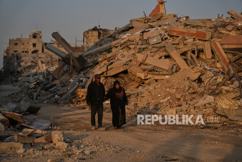 Warga Palestina melewati kehancuran akibat serangan udara dan darat Israel di Kota Gaza, Kamis, 23 Oktober 2025. 