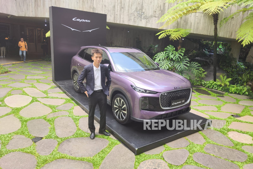 Deputy Country Director Lepas Indonesia Ricky He berfoto di samping depan Lepas L8, mobil PHEV lima penumpang.