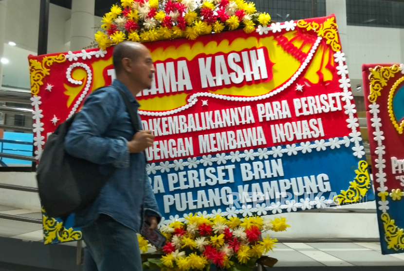 Karangan bunga ucapan terima kasih terkait kebijakan Peneliti Pulang Kampung terlihat di gedung BRIN. Jakarta Selatan, Senin (1/12/2025).