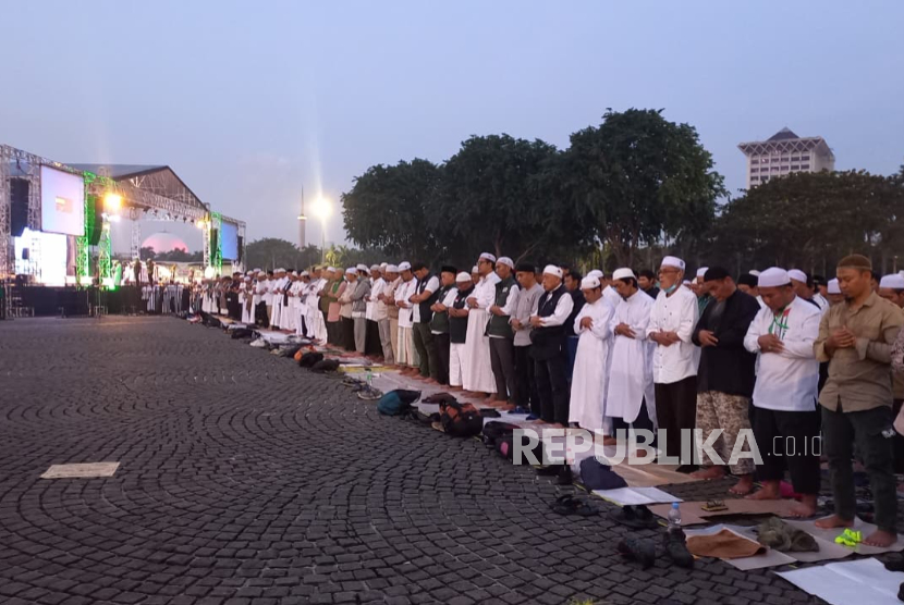 Jamaah Reuni 212 menggelar sholat Maghrib berjamaah di kawasan Monas, Jakarta Pusat, Selasa (2/12/2025) petang WIB.