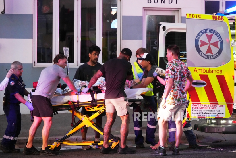 Petugas darurat mengangkut seseorang dengan tandu setelah dilaporkan adanya penembakan di Pantai Bondi, di Sydney, Ahad, 14 Desember 2025.