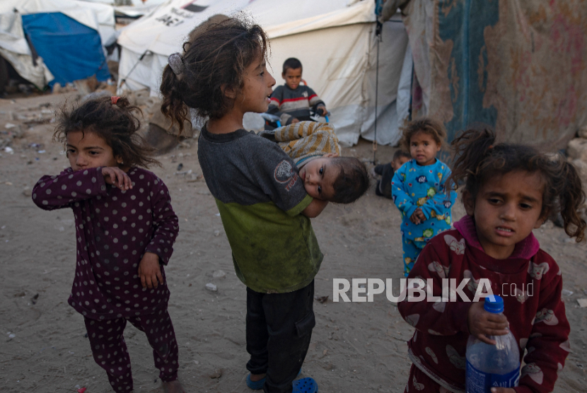 Seorang anak Palestina yang terlantar berjalan di pinggiran kamp tenda sementara di Khan Yunis, Jalur Gaza selatan, 27 Januari 2026.