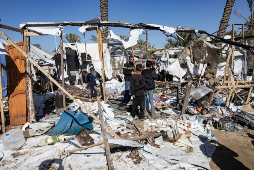 Warga Palestina memeriksa lokasi serangan udara Israel yang menargetkan kamp tenda yang menampung pengungsi di Khan Younis di Jalur Gaza selatan, 4 Februari 2026. Menurut Bulan Sabit Merah Palestina, setidaknya dua orang tewas dan 12 lainnya terluka dalam serangan itu.