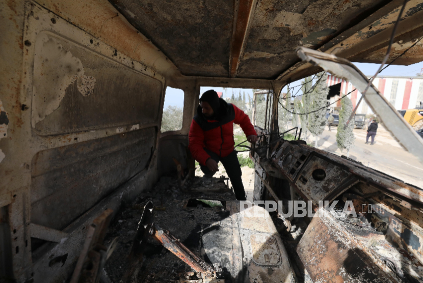 Seorang warga Palestina memeriksa dampak kebakaran yang dilakukan oleh pemukim Israel yang merusak mobil, di desa Awarta, selatan Nablus di Tepi Barat, 21 Januari 2026. 