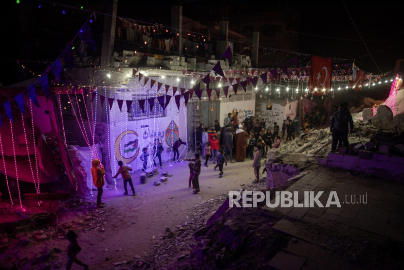 Warga Palestina yang mengungsi menggantungkan hiasan di atas reruntuhan rumah mereka yang hancur saat mereka bersiap menyambut bulan suci Ramadhan di Khan Yunis, Jalur Gaza selatan, Senin, 16 Februari 2026, di tengah gencatan senjata antara Israel dan Hamas. 