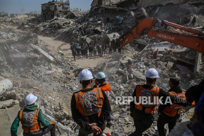 Tim pertahanan sipil Palestina bekerja untuk menemukan sisa-sisa 67 anggota keluarga Abu Nasr dari bawah reruntuhan rumah mereka yang hancur dalam serangan udara Israel di Beit Lahia, utara Kota Gaza, 15 Februari 2026.