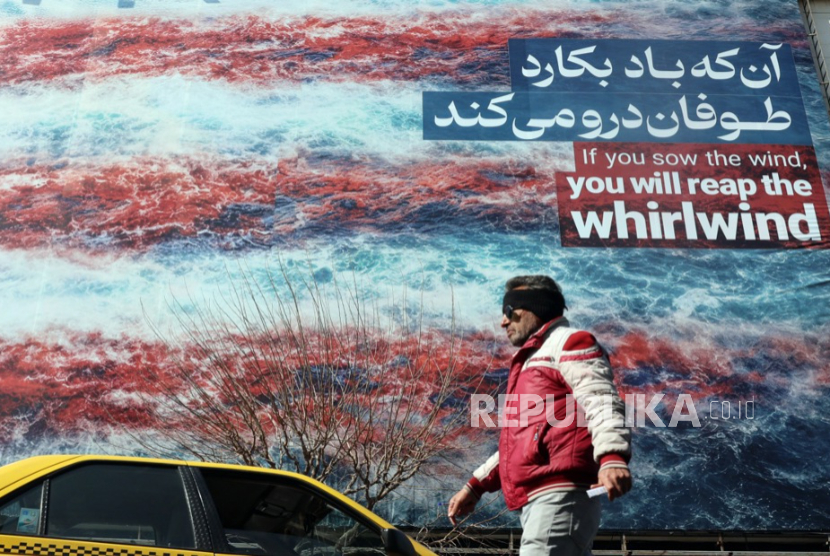 Warga Iran berjalan di samping baliho anti-AS di Teheran, Iran, 25 Februari 2026. 