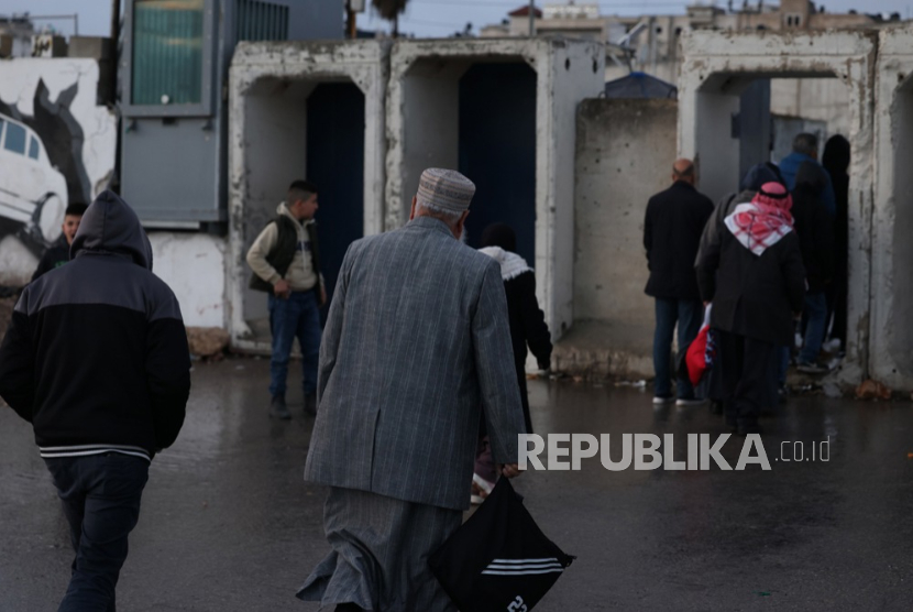 Warga Palestina mengantri untuk menyeberang di pos pemeriksaan Israel di Qalandia antara Tepi Barat dan Yerusalem, 27 Februari 2026, untuk menghadiri salat Jumat kedua Ramadhan di Masjid Al Aqsa di Yerusalem.