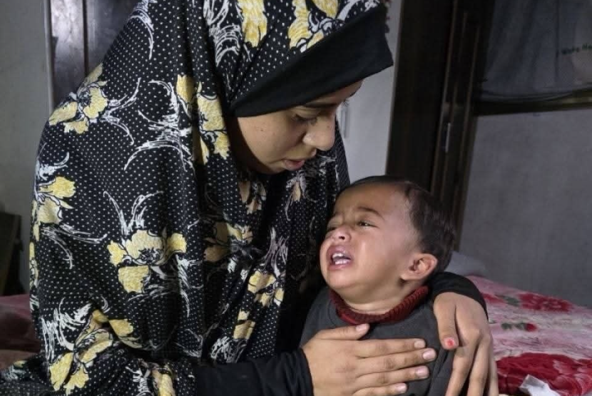 Karim Abu Nassar (18 bulan) ditenangkan oleh ibunya. Karim dilaporkan mengalami penyiksaan oleh tentara Israel pada 20 Maret 2026.