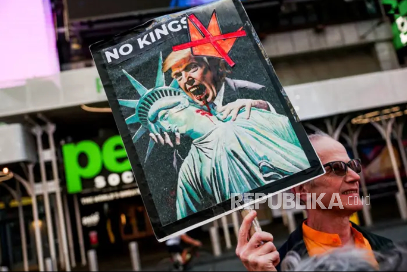 Seorang pria memegang plakat bergambar Presiden AS Donald Trump sebagai vampir saat protes Tanpa Raja di New York City, AS.
