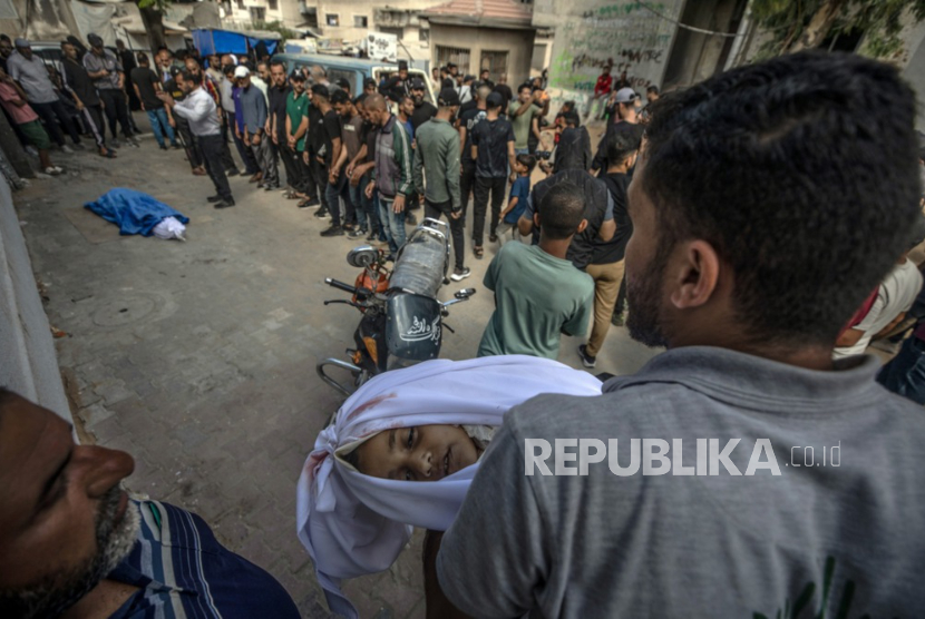 Seorang pria Palestina membawa jenazah Mariam Qadoum (8 tahun) saat pemakamannya bersama ayahnya, Abdallah Qadoum, di Rumah Sakit Al Shifa di Kota Gaza, 7 Juni 2026.