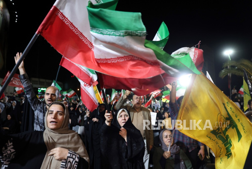 Orang-orang mengibarkan bendera Iran dan Hizbullah mendukung serangan Iran terhadap Israel, di alun-alun Valiasr di Teheran, Iran, 7 Juni 2026. Iran meluncurkan rudal ke Israel sebagai pembalasan atas serangan Israel sebelumnya di pinggiran selatan Beirut. 