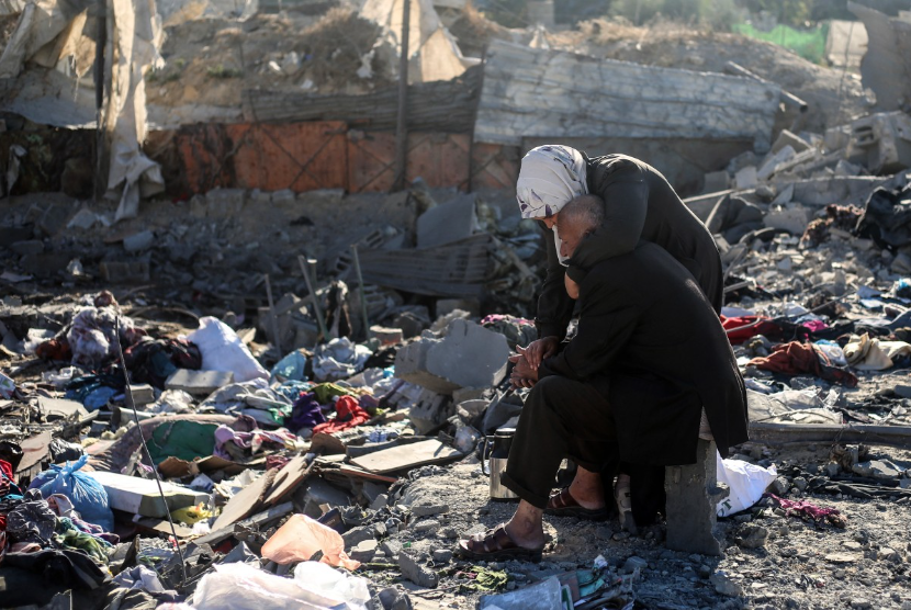 Sepasang warga Palestina duduk di tengah reruntuhan rumah yang hancur akibat serangan Israel di kamp pengungsi Bureij, pada 30 Oktober 2026.