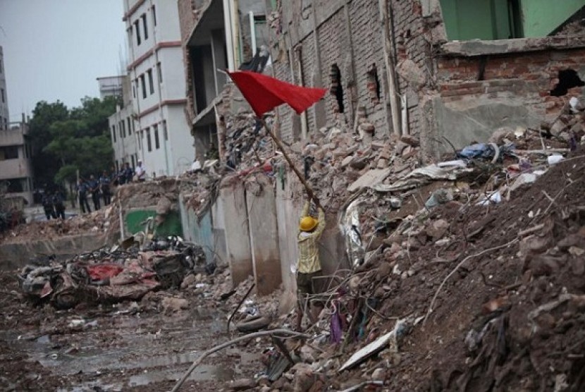 A Bangladeshi rescue worker puts a red flag, marking the end of rescue operations at the site where a Bangladesh garment-factory building collapsed on April 24 in Savar, near Dhaka, Bangladesh, Monday, May 13, 2013. 