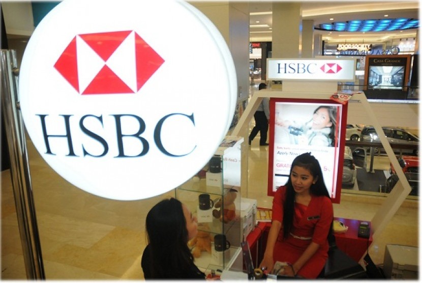 A bank teller of HSBC deals with a customer in a service counter. (illustration)