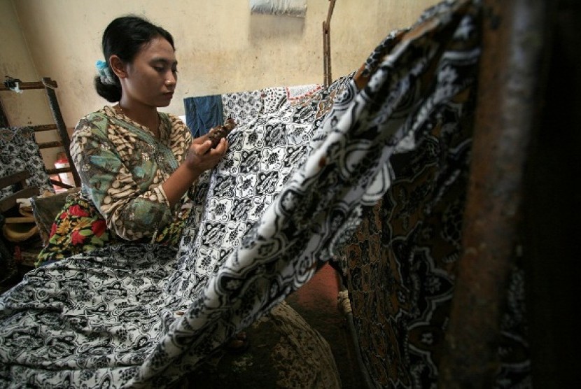 A batik artisan works in a batik workshop Paoman Art, Indramayu, West Java. (illustration)