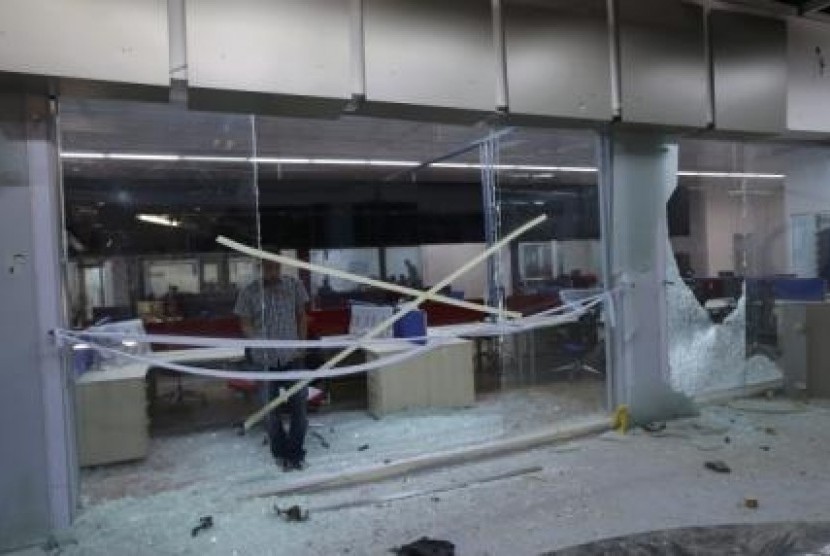 A Benghazi TV (BTV) employee inspects damage in the television station's studios after an artillery shell landed on its roof, in Benghazi July 9, 2014. 
