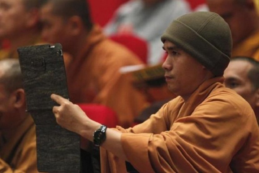 A Buddhist monk films, with an iPad, the closing ceremony of the seventh congress of Vietnam's Buddhist Sangha Association in Hanoi November 24, 2012.