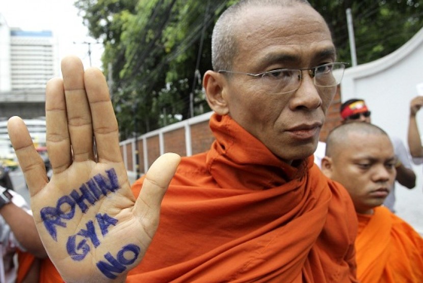 A Buddhist monk shows a message written in his palm to protest against the ethnic minority Rohingyas in Myanmar during a visit of Myanmar's President Thein Sein in Bangkok, Thailand, Tuesday, July 24, 2012. Communal violence is grinding on in western Myanm