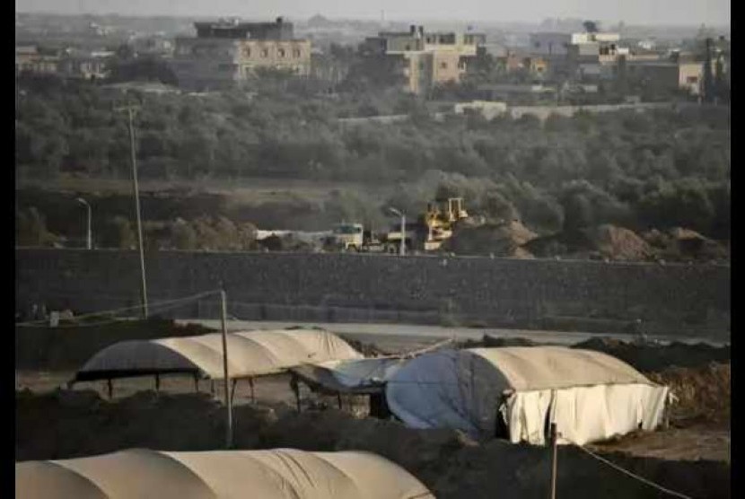   A bulldozer looks over smuggling tunnels along the border with Egypt as seen from Rafah, southern Gaza Strip, Sunday, Sept. 1, 2013.