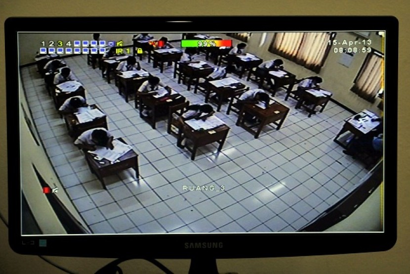 A CCTV helps teacher to monitor students doing their national exam at a vocational school in Jakarta, Monday. 