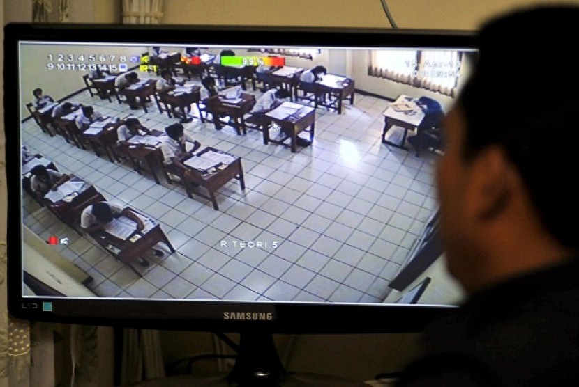 A CCTV helps teacher to watch students doing their national exam at a vocational school in Jakarta, Monday. 