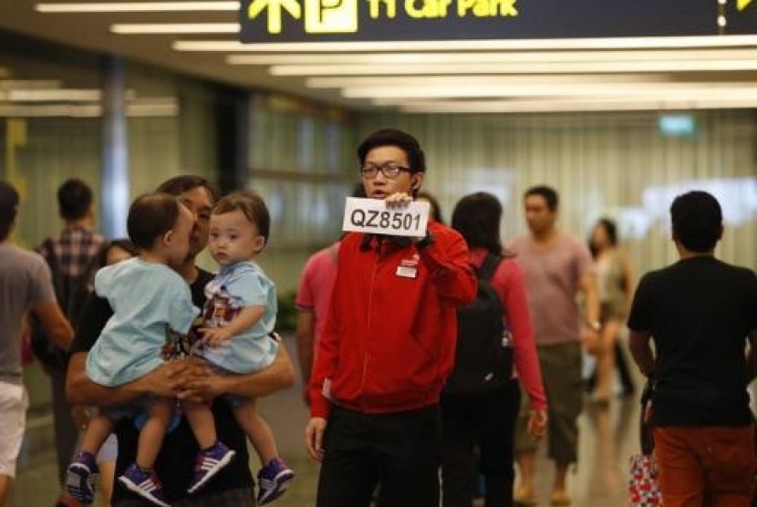 A Changi Airport staff holds up a sign to direct possible next-of-kins of passengers of AirAsia flight QZ 8501 from Indonesian city of 