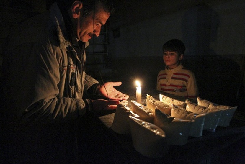 A child buys groceries at night in one of the markets in Aleppo January 8, 2013. Picture taken January 8, 2013.   