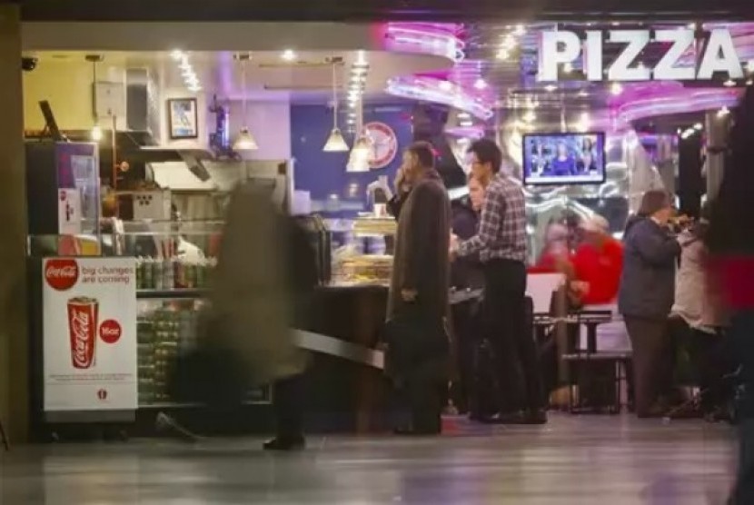 A Coca-Cola poster about the city's new beverage ban is displayed at a pizza shop, Friday, March 8, 2013, at New York's Penn Station.  