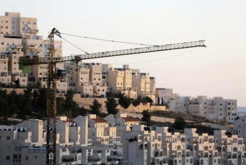 A crane is seen next to homes in a Jewish settlement near Jerusalem known to Israelis as Har Homa and to Palestinians as Jabal Abu Ghneim January 3, 2014.