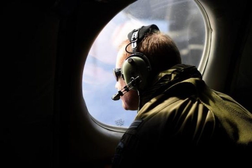 A crew member looks out an observation window aboard a Royal New Zealand Air Force (RNZAF) P3 Orion maritime search aircraft as it flies over the southern Indian Ocean on Saturday.