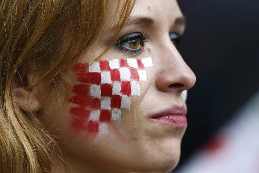 A Croatian fan with her face painted in national colours is pictured before their Group C Euro 2012 soccer match against Italy at the city stadium in Poznan, Thursday. Euro fever also hits Indonesia, as many football lovers do not mind to stay awake during