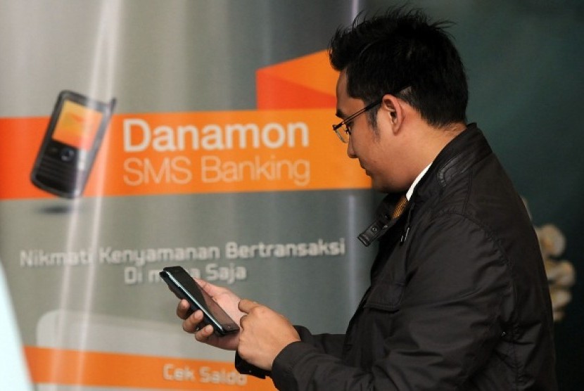 A customer tries sms banking service provided by Bank Danamon in Jakarta, this week. 