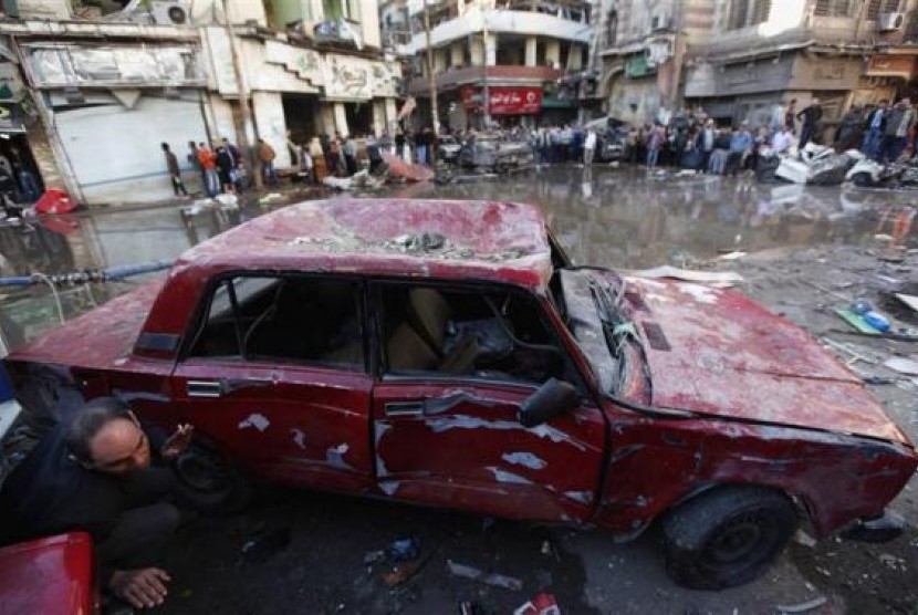 A damaged car is seen after an explosion near a security building in Egypt's Nile Delta city of Mansoura in Dakahlyia province, about 120 km (75 miles) northeast of Cairo December 24, 2013.