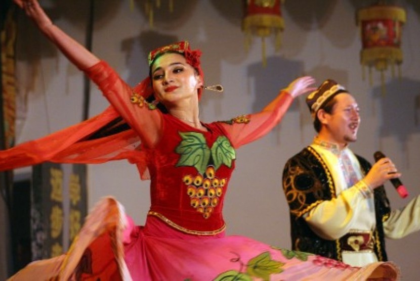 A dancer (left) from Xinjiang,China, performs a traditional Uyghur dance in Medan, North Sumatra on Friday night. 