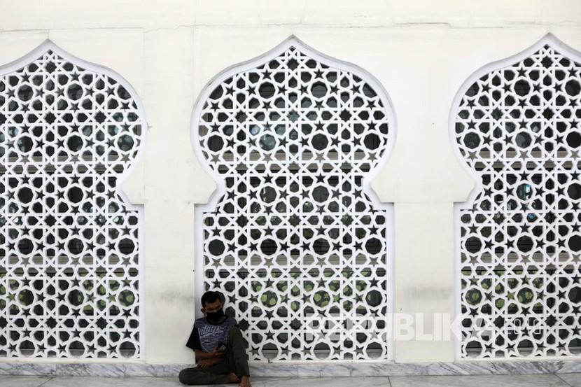 Seseorang tengah berdoa menggunakan masker di masjid agung raya Baiturrahman, Banda Aceh, Aceh.