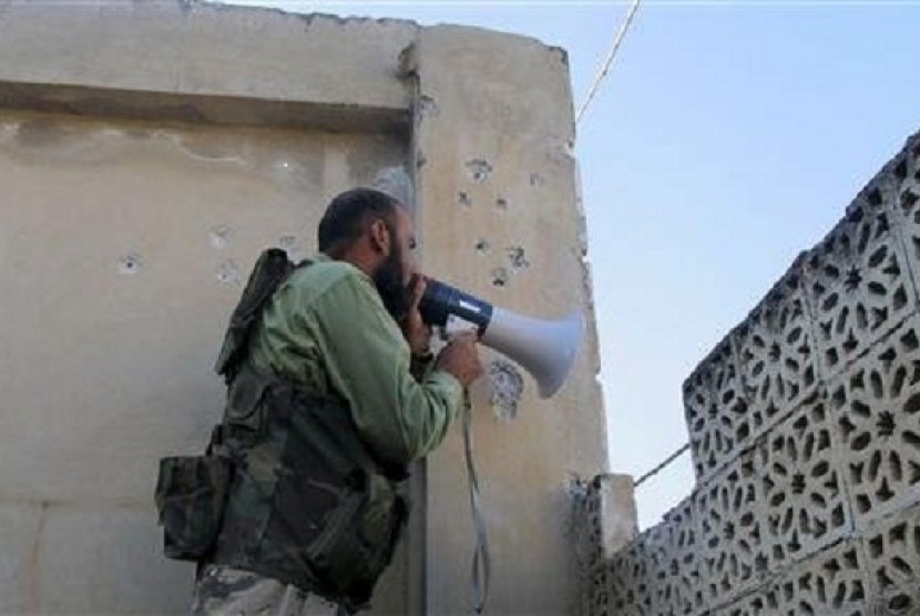 A Free Syrian Army fighter calls on Syrian regime troops to defect in the Khan al-Assal area, near Aleppo April 27, 2013. 