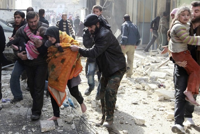 A Free Syrian Army fighter helps a family after a jet missile hit the al-Myassar neighbourhood of Aleppo February 20, 2013. 