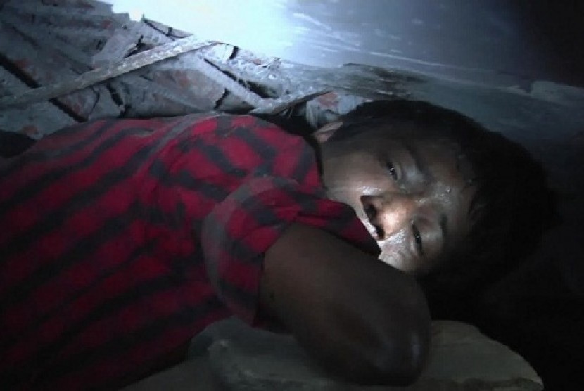 A garment worker Mohammad Altab moans to rescuers for help while trapped between concrete slabs and next to two corpses in a garment factory that collapsed Wednesday in Savar, near Dhaka, Bangladesh, Thursday, April 25, 2013. 