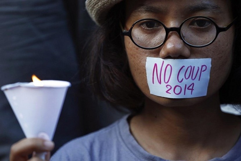 A girl holds a candle during a protest against military rule in central Bangkok, a day after Thai army chief seized power in a coup May 23, 2014. 