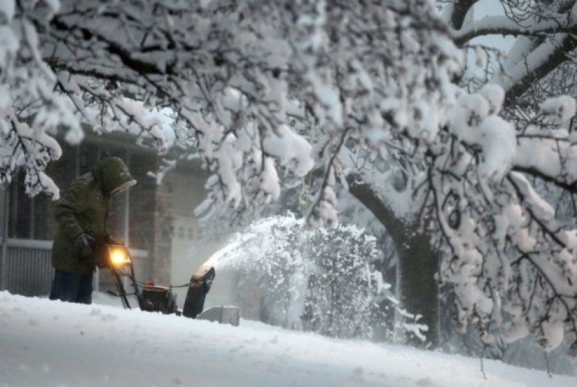 A local resident clears snow from his driveway after an overnight snowfall left many schools and businesses closed for the day, Thursday, Dec. 20, 2012, in Urbandale, Iowa. 