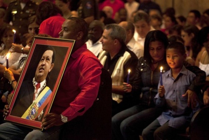 A man holds a framed image of Venezuela's President Hugo Chavez during a Mass to pray for the recovery of Chavez at the Cathedral, in Havana, Cuba, Saturday, Jan. 12, 2013. The 58-year-old president is fighting a severe respiratory infection a month after 