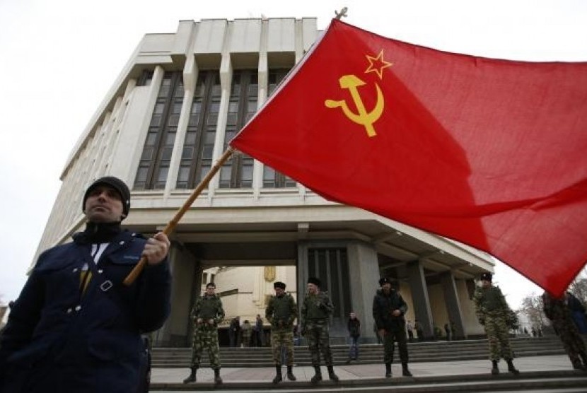 A man holds a Soviet Union flag as he attends a pro-Russian rally at the Crimean parliament building in Simferopol March 6, 2014.