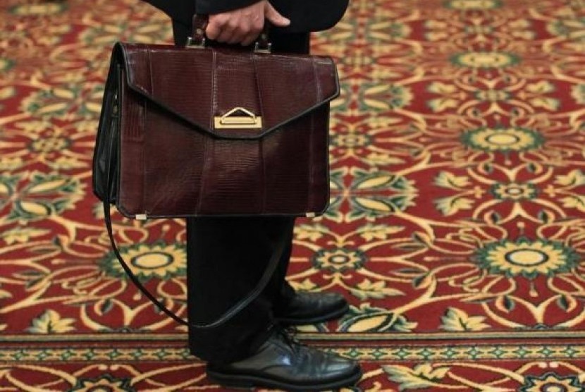 A man holds his briefcase while waiting in line during a job fair in Melville, New York July 19, 2012.