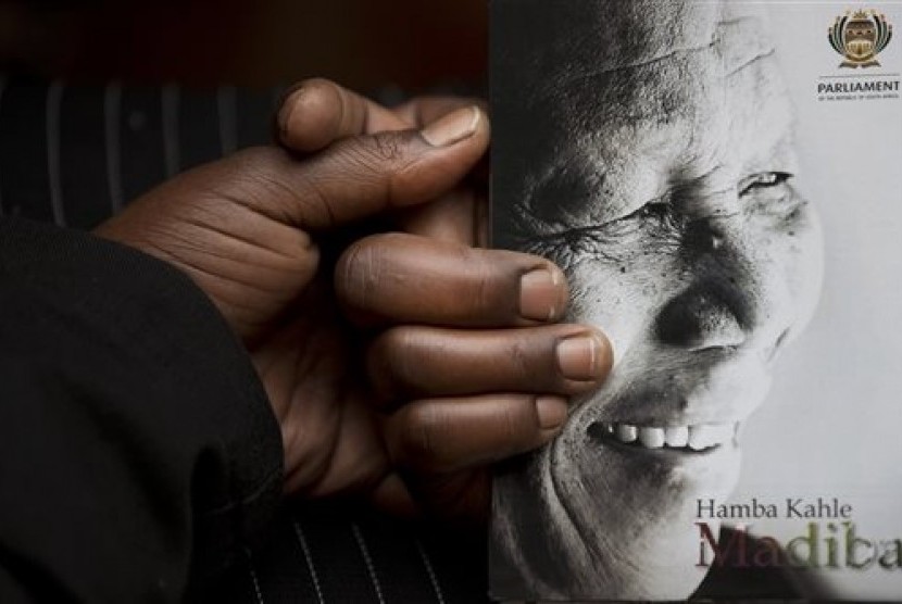 A man holds the official programme ahead of the memorial service for former South African president Nelson Mandela at the FNB Stadium in the Johannesburg, South Africa township of Soweto, Tuesday, Dec. 10, 2013. 