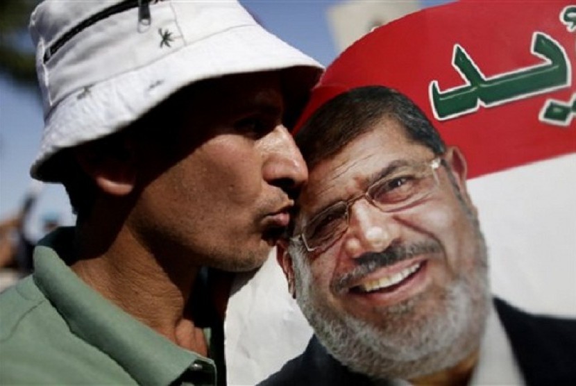A man kisses a poster with the photograph of Egypt's Islamist President Mohammed Mursi during a rally, in Nasser City, Cairo, Egypt, Wednesday, July 3, 2013. 