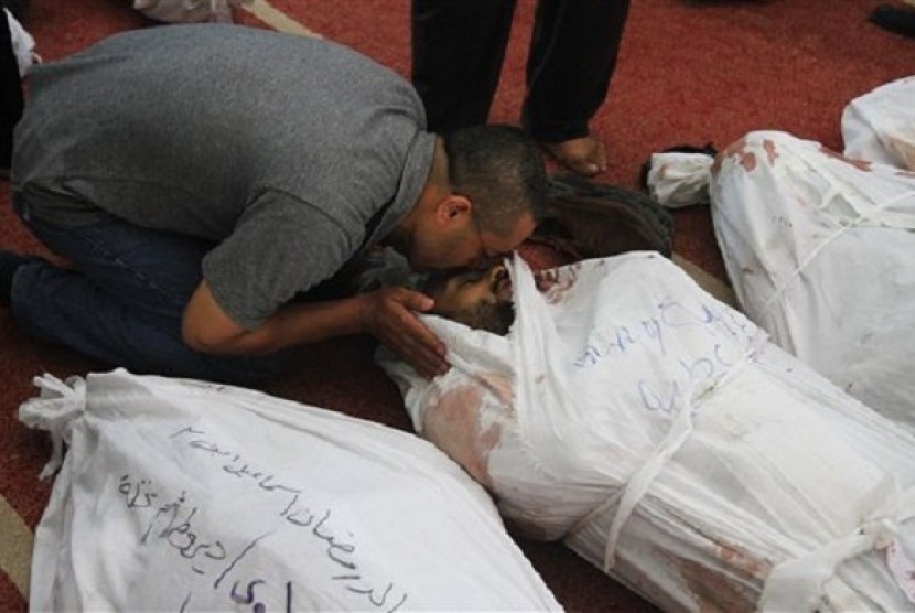 A man kisses the body of a supporter of ousted President Mohammed Mursi at the El-Iman mosque in Cairo's Nasr City, Egypt, Thursday, Aug. 15, 2013. 