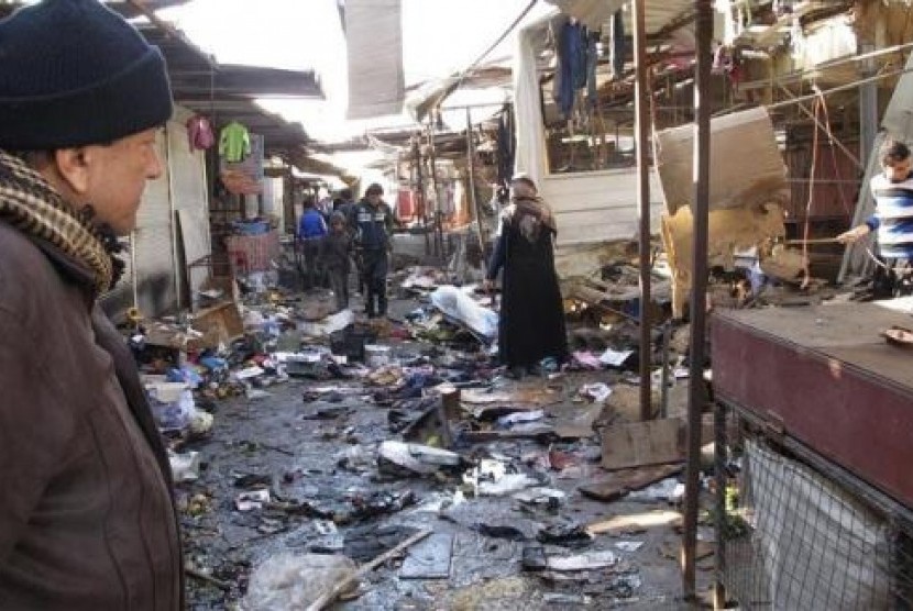 A man looks at the site of bomb attack at a marketplace in Baghdad's Doura District December 25 2013.