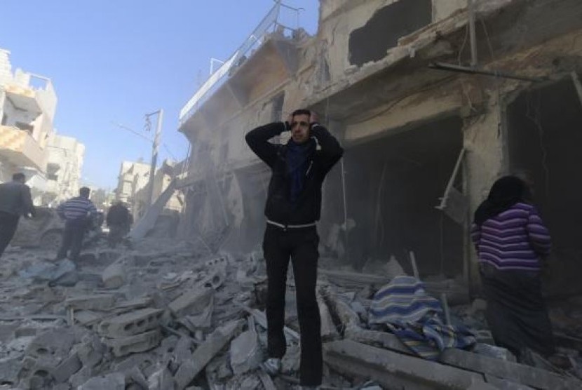 Seorang warga Suriah bereaksi saat menyaksikan reruntuhan akibat perang di Al-Haidariya, Aleppo, Suriah.